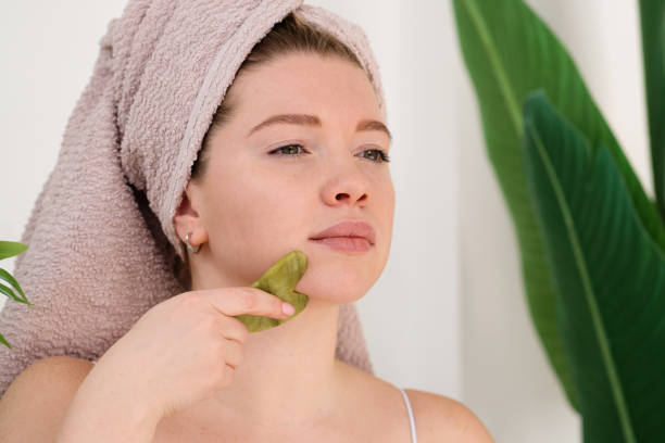istock Woman performing facial massage with gua sha 2108564135