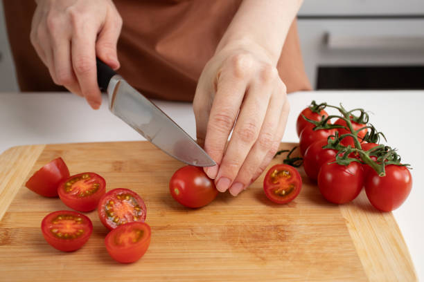 istock Woman's hands chopping cherry tomatoes, culinary preparation, vegetable cutting, meal planning 2108583904