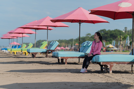 Asian lady rest at beach chair after done jogging