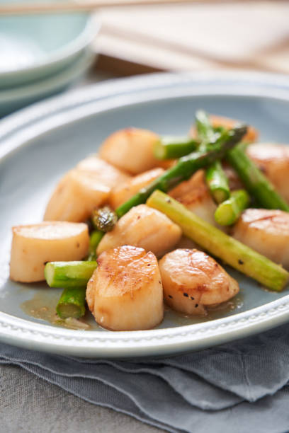 istock Sauteed scallops and asparagus with butter 2108609733