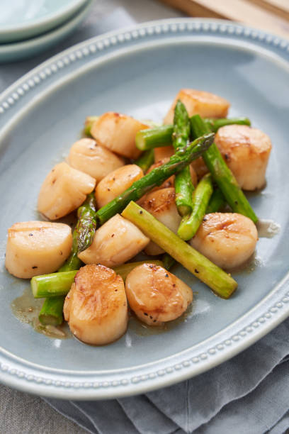 istock Sauteed scallops and asparagus with butter 2108612786