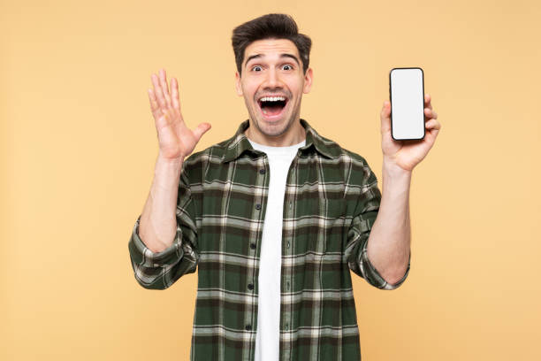 istock Excited, attractive man presenting an empty mobile phone screen, making an overjoyed gesture 2108621615