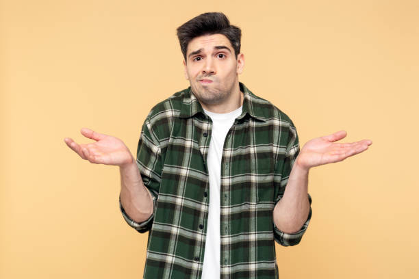 istock Upset man making a hand gesture, showing doubt through facial expression, isolated yellow background 2108621625