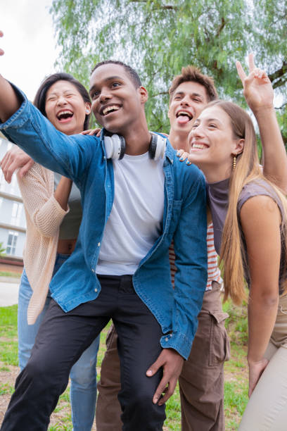 istock Vertical portrait Multiracial group of student friends laughing while taking a selfie 2108639323
