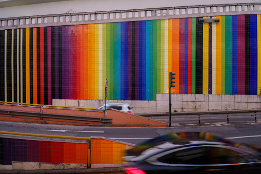 Vibrant Rainbow-Hued Tiled Wall Alongside Highway Ramp in Lisbon, Portugal at dusk February 2, 2024.