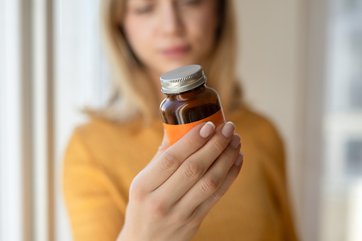 Woman holding supplement bottle