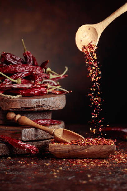 istock Chilli flakes are poured into a wooden dish. 2108695888