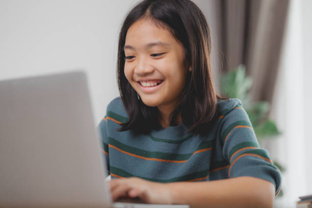 istock A young girl is smiling and using a laptop 2108696496