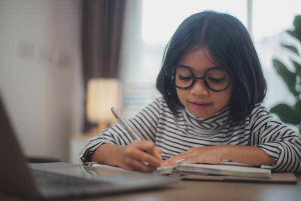 istock Cute Asian little girl children using a laptop computer, studying through an online e-learning system. 2108716877