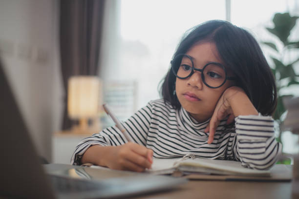 istock Cute Asian little girl children using a laptop computer, studying through an online e-learning system. 2108716878