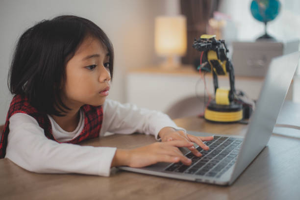 istock STEM education concept. Asian students learn at home by coding robot arms in STEM, mathematics engineering science technology computer code in robotics for kids' concepts. 2108734119