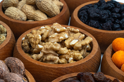 Healthy dried nuts and fruits in wooden bowl. Walnuts in wooden bowl.