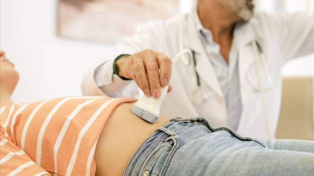 Doctor doing abdomen ultrasound examination of woman in hospital stock photo