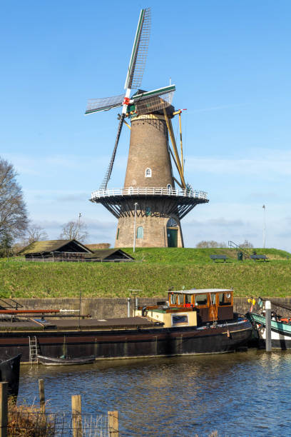 Gorinchem, the Netherlands. 27 February 2024. Windmill with the name “Molen Nooit Volmaakt'' is one of the two flour mills on the ramparts. The mill is still running in the fortified city of Gorinchem