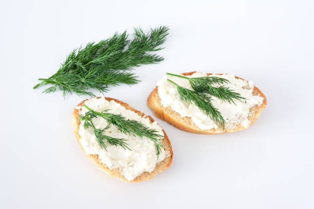 two slices of bread with green dill on top isolated on white