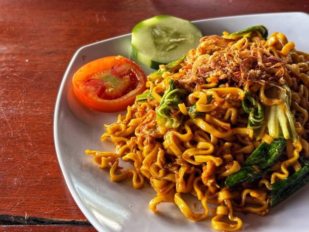 istock Indonesian fried noodles served with tomatoes and cucumbers 2108912230