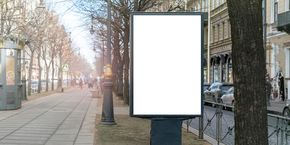 Freestanding advertisement display with blank screen on city sidewalk. Perfect for outdoor advertising mockup and dynamic urban environment