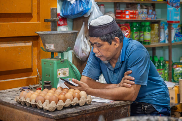 Sabang, Pulau Weh, Indonesia - January 14th 2024: Marked vendor with his stock of eggs at a market stall in the marked hall in the city of Sabang which in the main city on the island Weh north of Sumatra