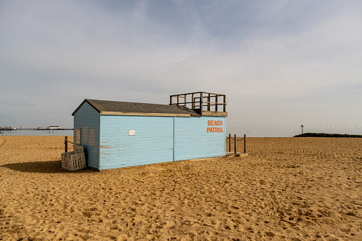 Wooden beach patrol hut on the sandy beach in the coastal town of Clacton-on-Sea, Essex