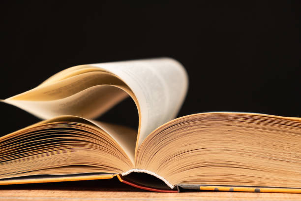 istock Pages of a thick book are turned on a black background. 2108990564