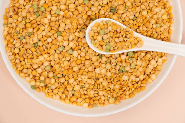 istock Pea yellow groats grains cereal in spoon close-up macro. 2108995715