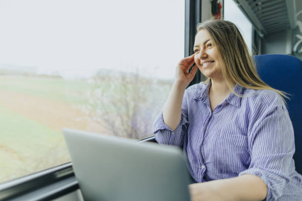 istock Beautiful young woman using laptop while commuting by train 2109008219