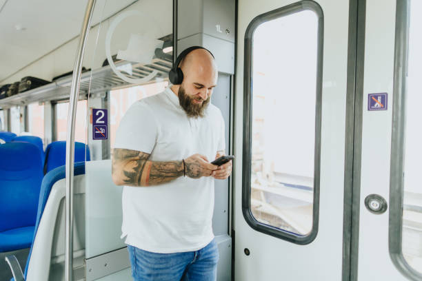 istock Young man listening to music while traveling by train 2109019094