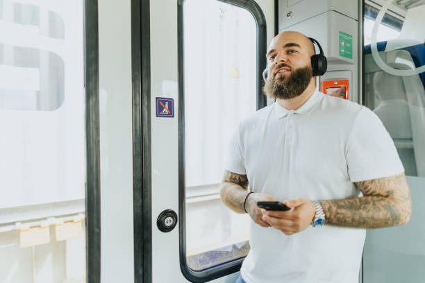 istock Young man listening to music while traveling by train 2109019198