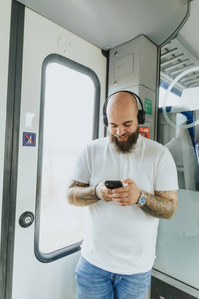 istock Young man listening to music while traveling by train 2109019622
