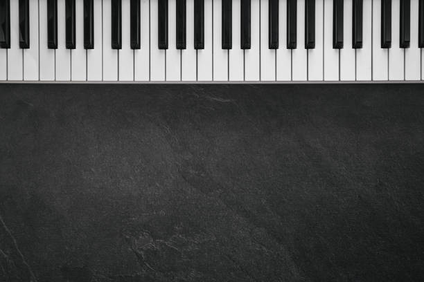Musical keyboard on a textured black background, flat lay, copy space.