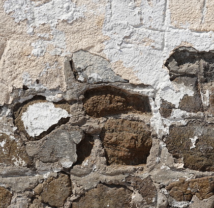 Close-Up Of Peeling White Paint On Aged Stone Wall Texture