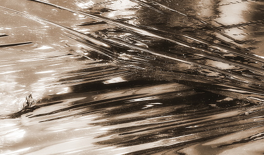 Sepia-Toned Abstract Shimmering Textures Of Crinkled Plastic Film