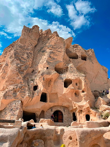 Ancient Cappadocia Cave Dwellings Under Blue Sky With Fluffy Clouds