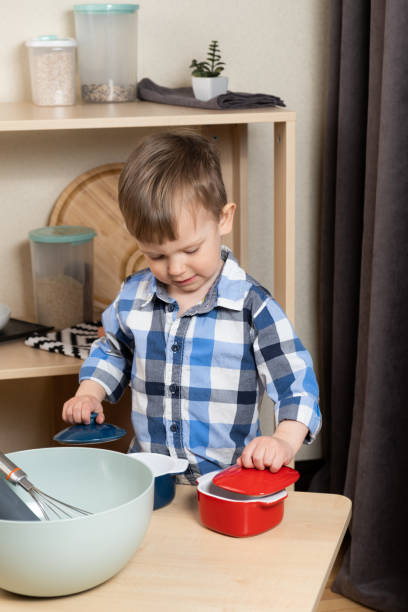 istock A two-year-old boy cooking in the kitchen, making dough. Cooking and kids 2109080228