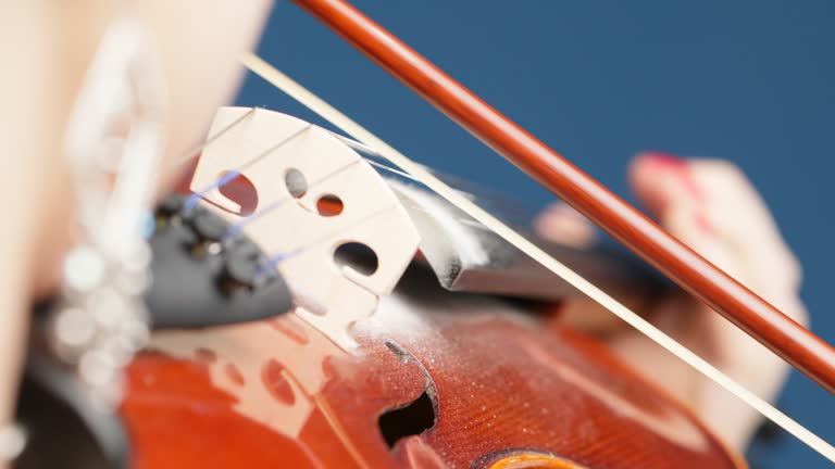 extreme closeup over the violin's bridge playing
