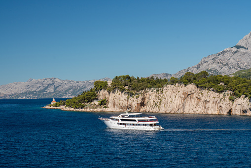 A large cruise ship leaves the port for the sea. Beautiful coastline. Sunny day in Croatia