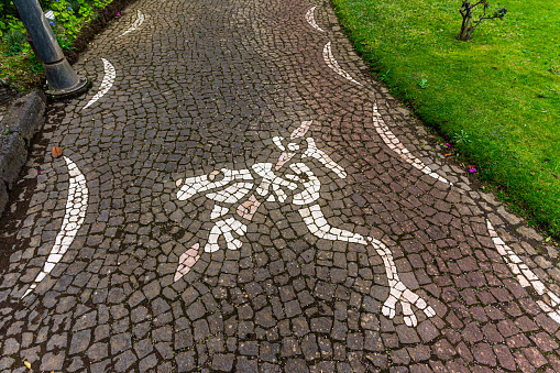 Angra do Heroismo, Azores, Portugal. March 11, 2024. Quaint Portuguese cobblestone sidewalk adorned with a frog motif, captured in the Duques da Terceira Garden in Angra do Heroísmo.