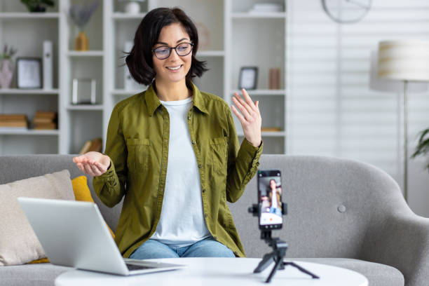 istock Professional woman creating content for online audience with smartphone and laptop 2109138036