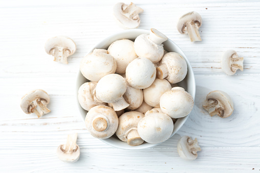Many raw mushroom champignon  on wooden background . Top view