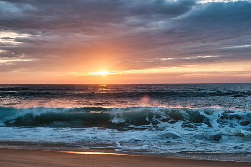 waves of the altlantic ocean crushing onto the beach at the cote de argent in France with golden sunset in the background, Cap Ferret, Aquitaine, France