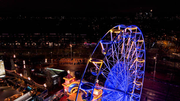 istock Illuminated Ferris Wheel at Night, A dark night sky and a brightly illuminated funfair wheel, Amusement Park Night View, Illuminated Ferris Wheel, Illuminated Ferris Wheel in Amsterdam at Night 2109236525