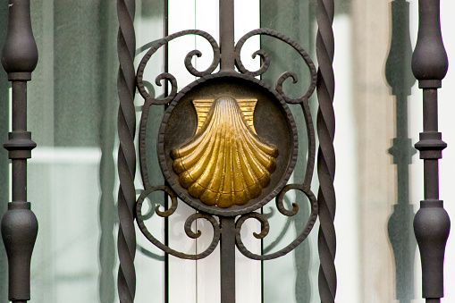 Cast iron railing detail and  carved scallop , Camino de Santiago symbol. Ancient pilgrimage route, UNESCO world heritage. Santiago de Compostela, Galicia, Spain.