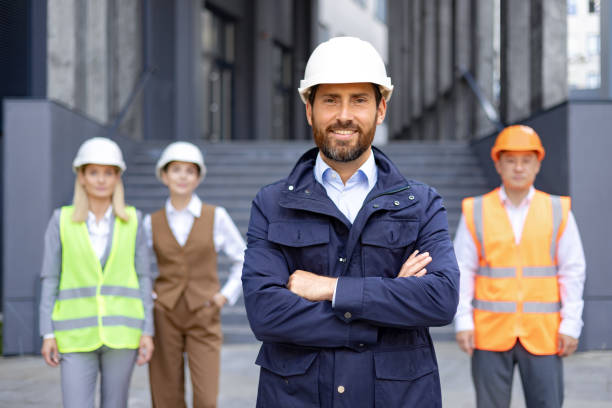 istock Confident construction manager with team in safety gear at modern building site 2109269548