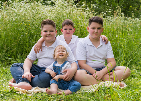 A big happy family, 4 brothers of different ages in nature, the youngest is one year old. All the boys are full and cheerful