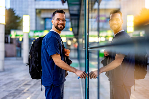 Male nurse entering hospital. Young adult male nurse arrives to work male nurse male healthcare and medicine technician stock pictures, royalty-free photos & images