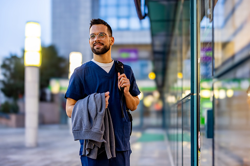 Young adult male nurse traveling through the city