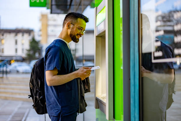 istock Man inserting a credit card into an ATM 2109281063