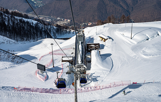 ski lift gondolas against blue sky over slope at ski resort on sunny winter day