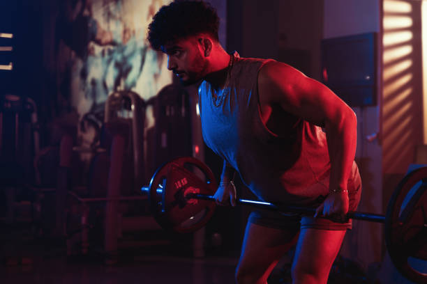 Focused Barbell Row in a Misty Gym Settin