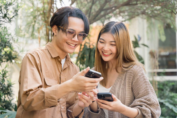 istock Joyful Couple Sharing Content on Smartphones. 2109325208